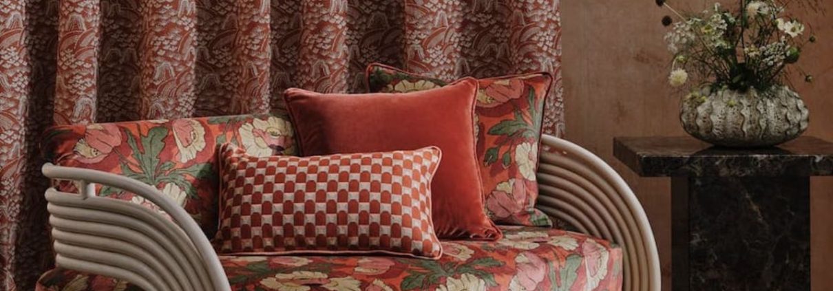 A braided jute rug beneath a sofa with red cushions