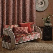 A braided jute rug beneath a sofa with red cushions